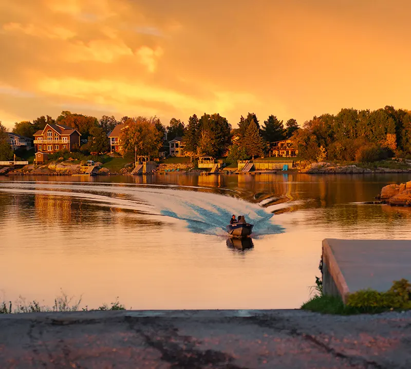 A boat arrives at the boat launch in Keewatin at sunset.