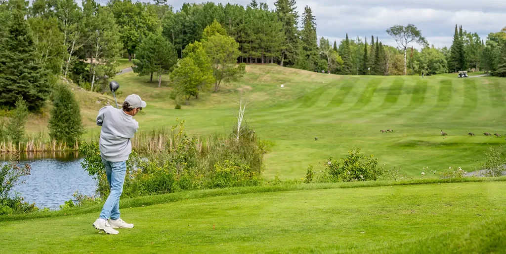 A golfer swings on the green at one of Kenora's two golf courses.